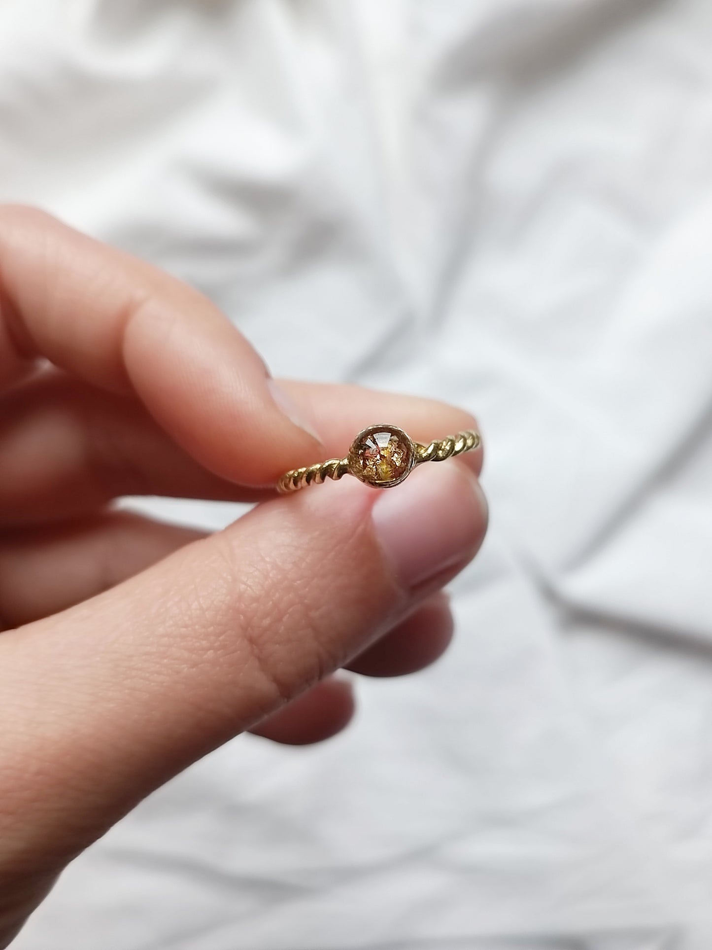 Anello in ottone regolabile attorcigliato con mix di frammenti di fiori e foglia oro